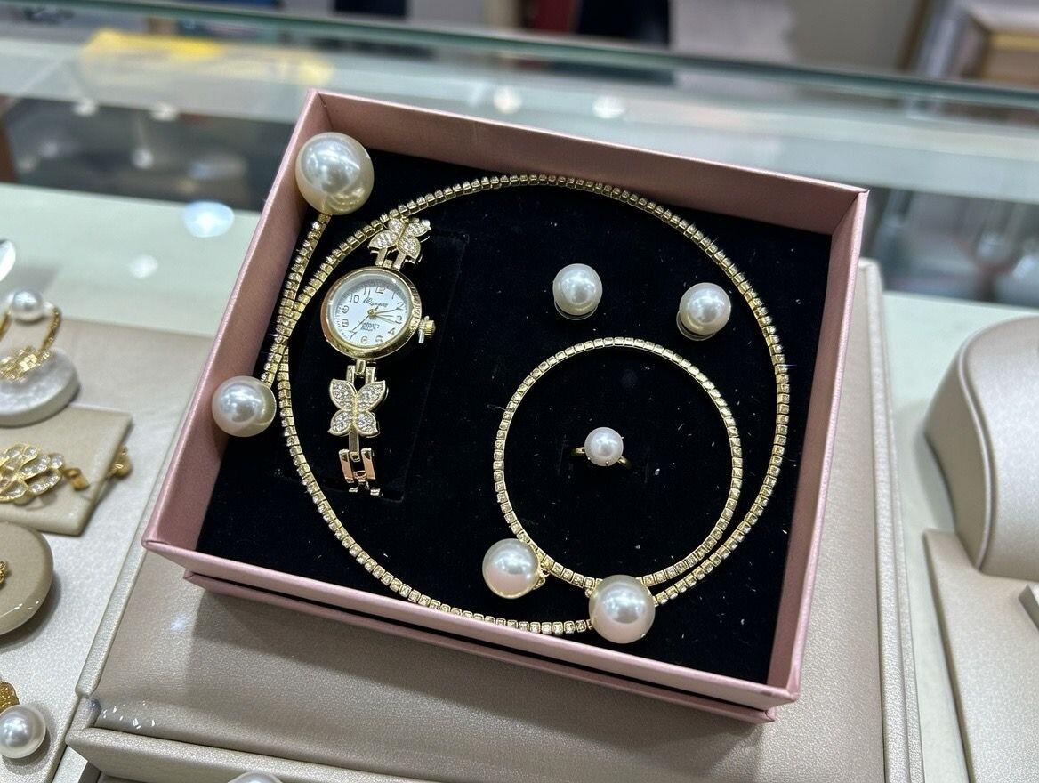 Conjunto de joyas dorado con perlas aleatorio.